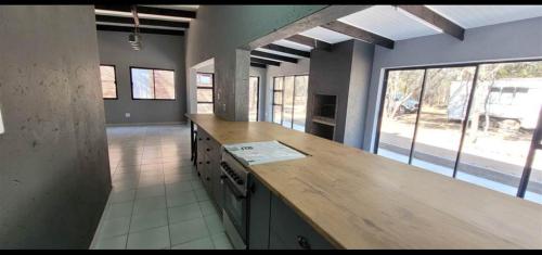 eine große Küche mit einer hölzernen Arbeitsplatte in einem Zimmer in der Unterkunft Woodpecker Villa Guesthouse in Thabazimbi