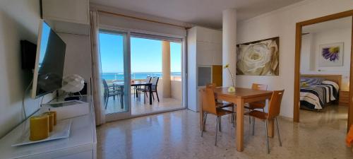 Apartamento Junto al Mar في أوليفا: غرفة معيشة مع طاولة طعام مطلة على المحيط