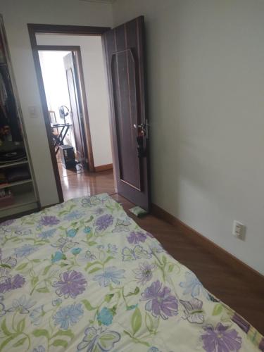 1 dormitorio con 1 cama con colcha de flores en Quarto em apartamento no centro de Blumenau !, en Blumenau