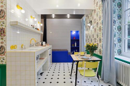 a kitchen with a table and yellow chairs at LE SIMONE -Centre Historique in Rennes