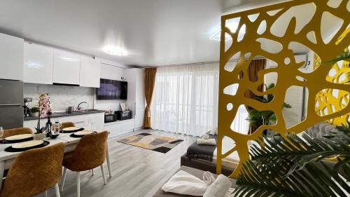 eine Küche und ein Wohnzimmer mit Tisch und Stühlen in der Unterkunft Havana Studio-Alezzi Nord 10 (piscina&loc parcare) in Năvodari