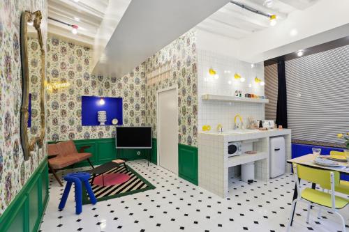 a living room with green and white walls and a kitchen at LE SIMONE -Centre Historique in Rennes