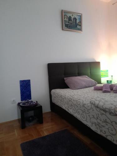 Schlafzimmer mit einem Bett und einem Beistelltisch in der Unterkunft Apartman Mančić in Pirot