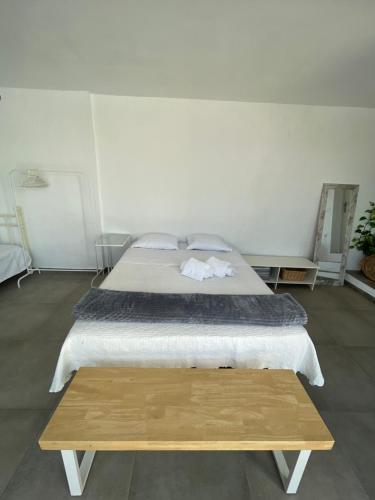 a bedroom with a large bed and a wooden table at MEDITERRANEAN HOUSE - Habitaciones Privadas en Casa Compartida in Mairena del Aljarafe