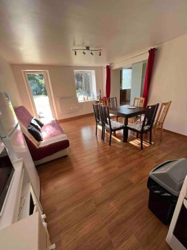 un salon avec une table et des chaises de salle à manger dans l'établissement Proche Disney, appartement au calme, à Couilly-Pont-aux-Dames