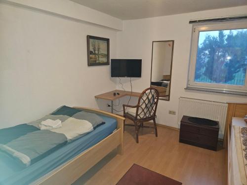 Un dormitorio con una cama, un escritorio y una silla. en C & R Zimmervermietung, en Hannover