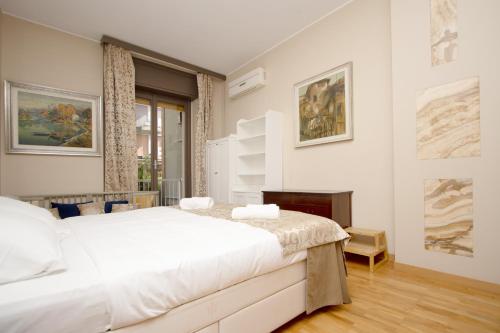 una camera da letto con un grande letto bianco e una finestra di Note D'Artista-Duomo 15 minutes a Milano