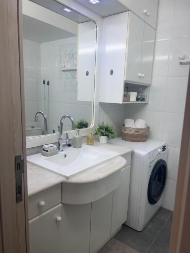 a white bathroom with a sink and a washing machine at Apartments 1126 Colony Beach with Pool Bat Yam Tel Aviv in Bat Yam