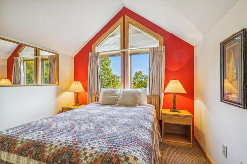 1 dormitorio con paredes rojas y 1 cama con 2 lámparas en Welcoming Two bedroom Highridge Condo J3, en Killington