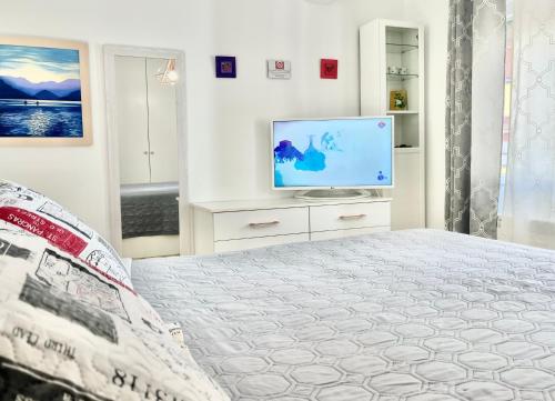 a white bedroom with a bed and a tv at In Love Zamora in Zamora