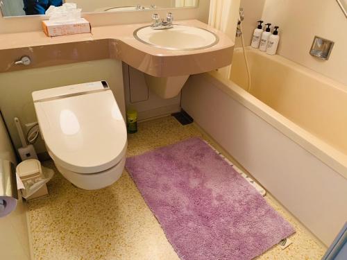 a bathroom with a toilet and a sink with a purple rug at Starry Sky and Sea of Clouds Hotel Terrace Resort - Vacation STAY 75205v in Takeda