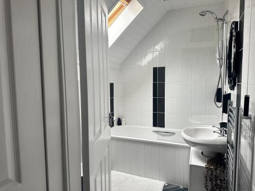 y baño blanco con lavabo y bañera. en The Sandgate New Immaculate 1-Bed Apartment in Ayr, en Ayr