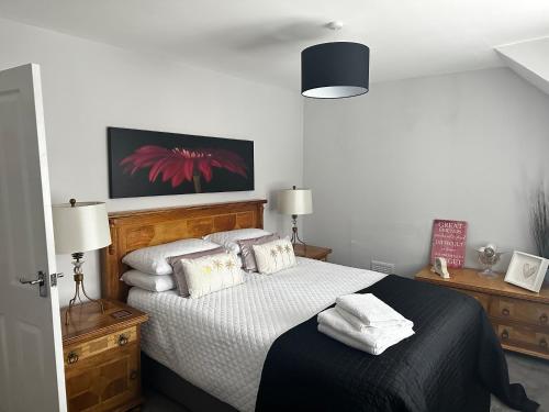 una camera da letto con letto, lenzuola e cuscini bianchi di The Sandgate New Immaculate 1-Bed Apartment in Ayr ad Ayr