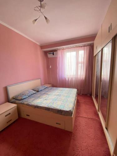 um quarto com uma cama num quarto cor-de-rosa em Cozy corner right in the center! em Tashkent
