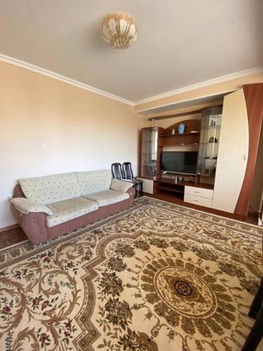 uma sala de estar com um sofá e um tapete em Cozy corner right in the center! em Tashkent