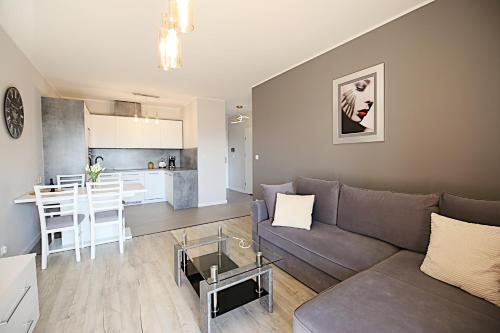 een woonkamer en een keuken met een bank en een tafel bij Apartimento Angel River 9 in Wrocław