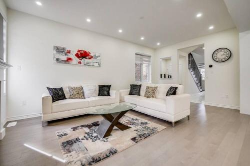 a living room with two white couches and a clock at 922 Logan Drive in Milton