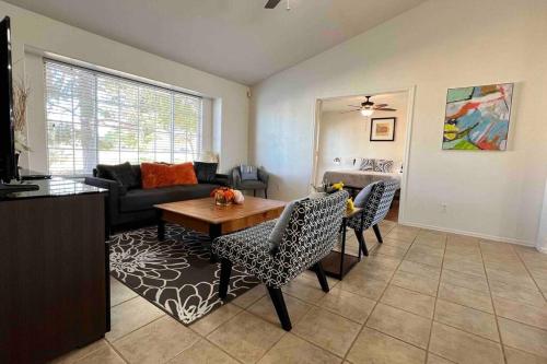 Una sala de estar con un sofá, una mesa y sillas. en Cozy 3 Bedrooms Town home in Chandler with community pool, en Chandler