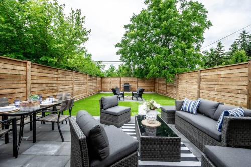 a backyard patio with furniture and a fence at Luxury Stylish Home, Walk to Falls, Fire Pit&More in Niagara Falls