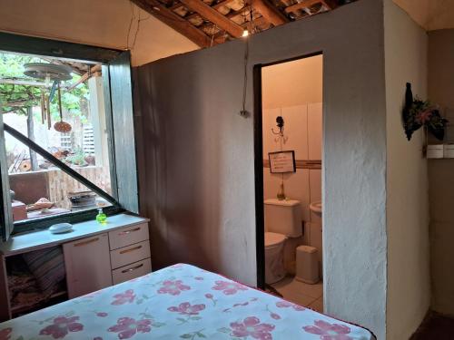 y baño con cama, lavabo y aseo. en Casa por temporada en Goiás