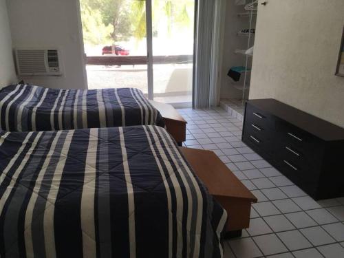 1 dormitorio con 2 camas y baño con ventana en HOUSE FRONT OF THE SEA, en Progreso