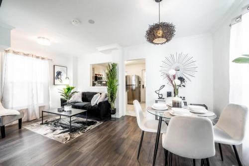 a living room with a table and white chairs at Luxury Stylish Home, Walk to Falls, Fire Pit&More in Niagara Falls