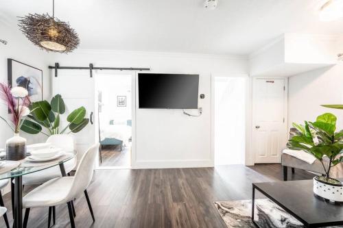 a living room with a table and a tv at Luxury Stylish Home, Walk to Falls, Fire Pit&More in Niagara Falls