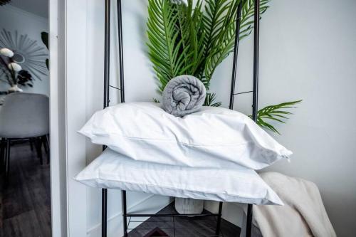 - un tas d'oreillers sur une table avec une plante dans l'établissement Luxury Stylish Home, Walk to Falls, Fire Pit&More, à Niagara Falls