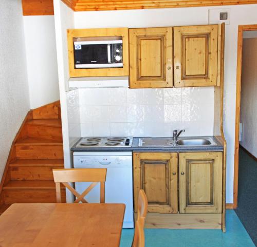 a small kitchen with a sink and a stove at Lagrange Vacances Les Valmonts de Val Cenis in Lanslebourg-Mont-Cenis