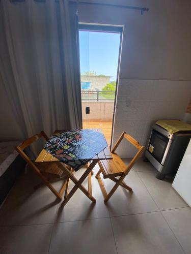 uma mesa e duas cadeiras numa sala com um fogão em Residencial Aquidabã em Angra dos Reis