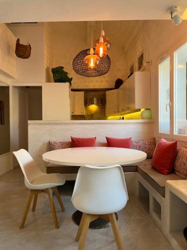 une salle à manger avec une table et des chaises et une cuisine dans l'établissement Lou Parpaiou by K6Conciergerie, à Cassis