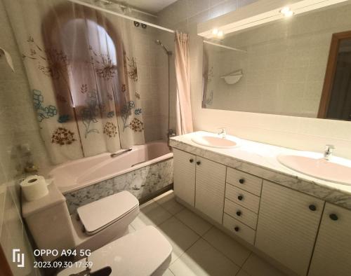 een badkamer met een wastafel, een toilet en een bad bij Wonderful Beach House with 2 Pools in Calafell