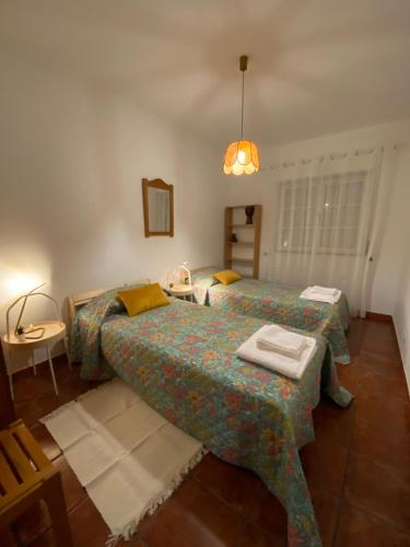 sypialnia z 2 łóżkami, stołem i lampką w obiekcie À do Matias w mieście Mourão