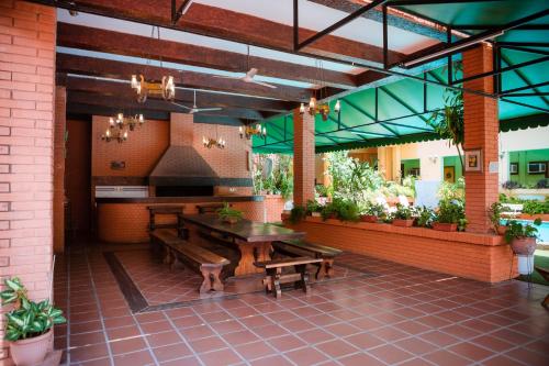 un restaurante con mesa, bancos y plantas en Hotel Santo Domingo en Asunción