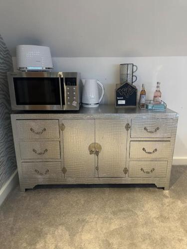 a microwave oven sitting on top of a cabinet at Cozy 1 bed Urban Haven in Swithland