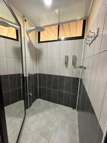 W łazience znajduje się prysznic ze szklanymi drzwiami. w obiekcie Hope Garden w mieście Sarapiquí