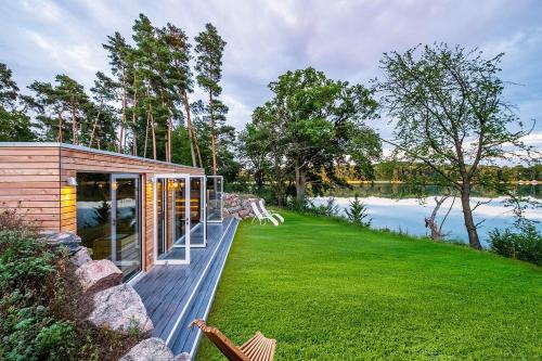 a house with a deck next to a body of water at Seehotel Lichtenberg in Lichtenberg
