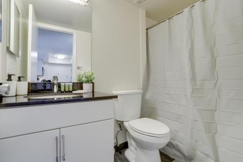 a white bathroom with a toilet and a sink at Stylish and charming Apartment in Pentagon City in Arlington