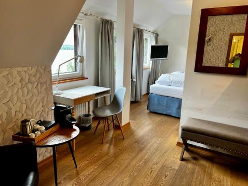 ein Hotelzimmer mit einem Bett, einem Schreibtisch und einem Schlafzimmer in der Unterkunft Fischerklause am Lutjensee in Lütjensee