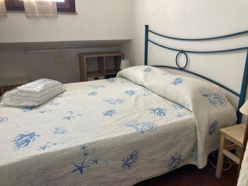 ein blau-weißes Bett mit einer blauen und weißen Bettdecke in der Unterkunft Villasimius villetta a 300 mt dalla spiaggia in Villasimius