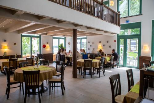 um restaurante com mesas e cadeiras e pessoas sentadas a mesas em Hotel Restaurant Auerhahn em Bad Wildbad