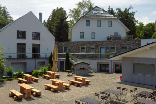 um pátio com bancos e mesas de madeira em frente a um edifício em Hotel Restaurant Auerhahn em Bad Wildbad