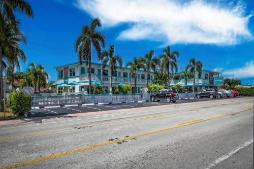 a street with a building and palm trees on the side of a road at Horizon by the Sea Inn in Fort Lauderdale