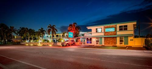 a building with a truck parked next to a street at Horizon by the Sea Inn in Fort Lauderdale