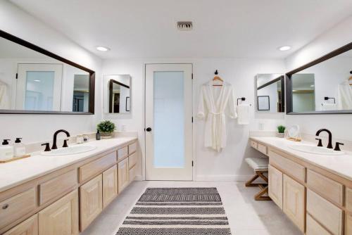 a bathroom with two sinks and two mirrors at Cali Desert Life - Pool, Golf Cart, Tennis, Bikes in Indian Wells