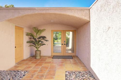 a house with a potted plant in front of a door at Cali Desert Life - Pool, Golf Cart, Tennis, Bikes in Indian Wells