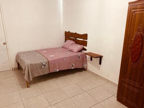 uma pequena cama num canto de um quarto em El Paso em David