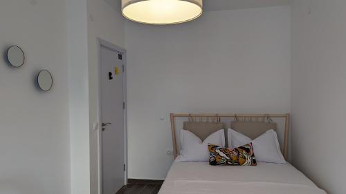 a bedroom with a bed with pillows and a light at 65 Duck House in Sofia