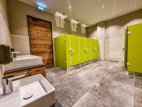a bathroom with green lockers and a sink and a toilet at Camping Essenza Alpina in Folgaria
