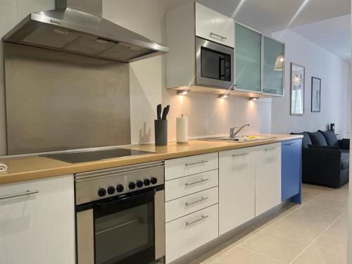 a kitchen with white cabinets and a stove top oven at Cala Alta Sea Dreams in Benidorm